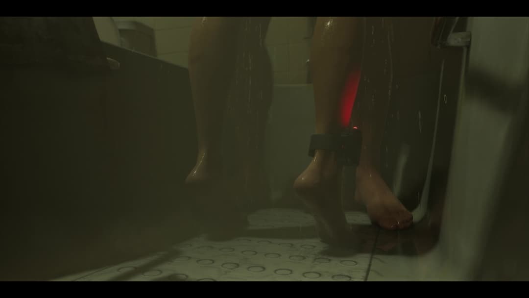 La tobillera electrónica de Lucía con una luz roja en la escena de la ducha en el minuto 0:52 del tráiler de lanzamiento de GTA VI